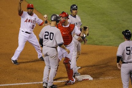 Angels catcher Mike Napoli appears to tag out both Robinson Cano and Jorge Posada in the fifth inning, but only Posada is called out by third-base umpire Tim McClelland.